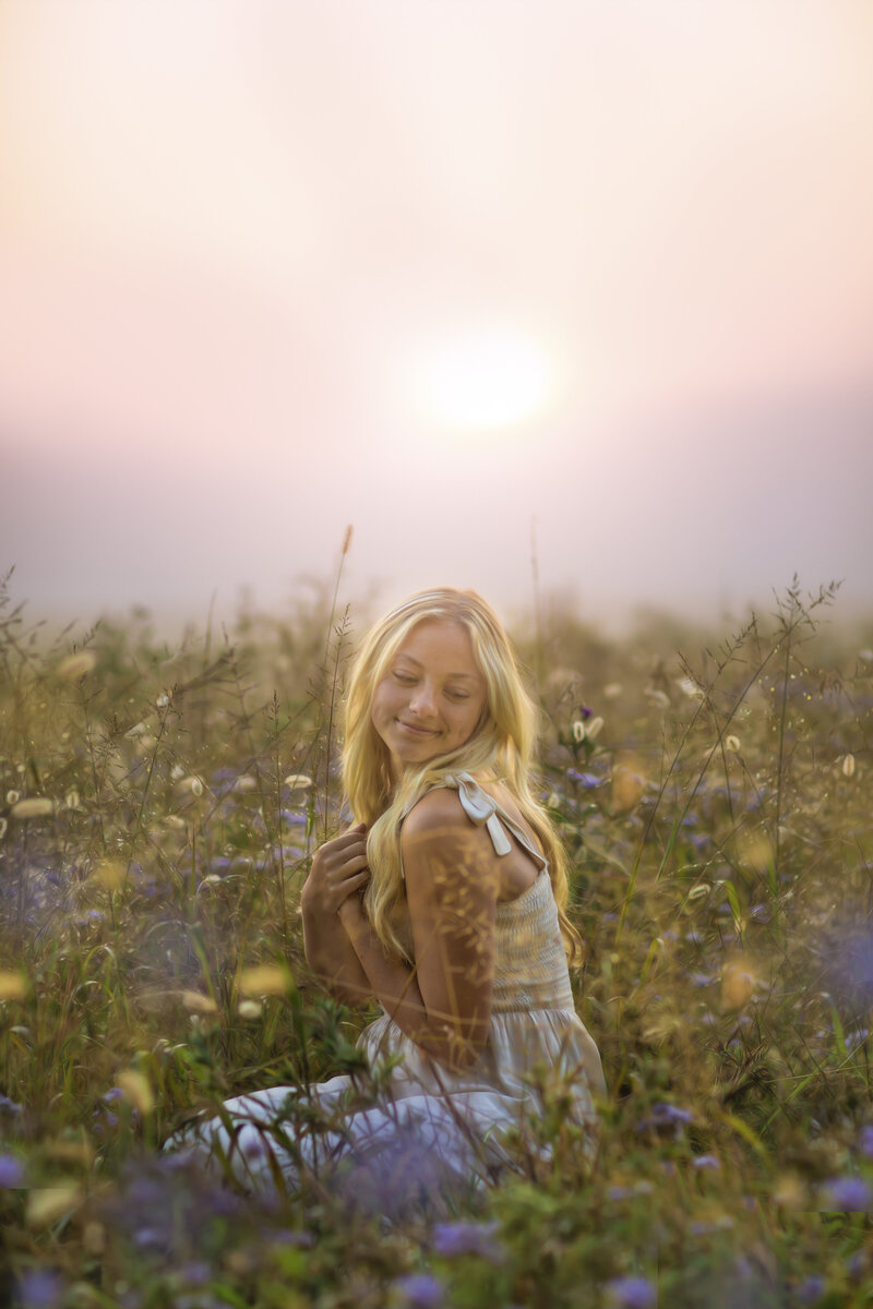 Gorgeous sunset portrait of a high school senior in a field of wildflowers