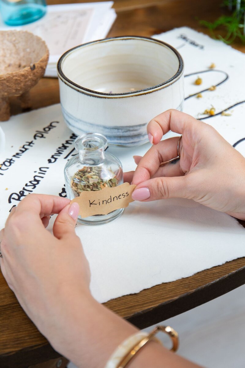 Tea leaves arranged with the word "kindness" next to a bowl, representing the gentle, compassionate approach central to Merlyn Asencio’s trauma therapy practice in Miami.