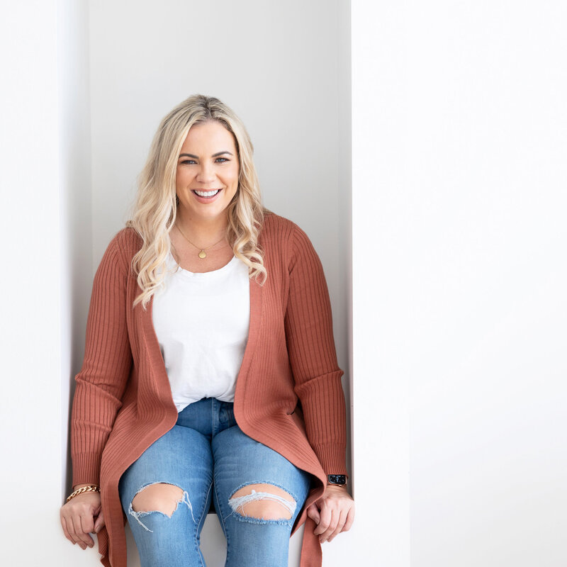 pa woman wearing jeans and a rusty coloured cardigan