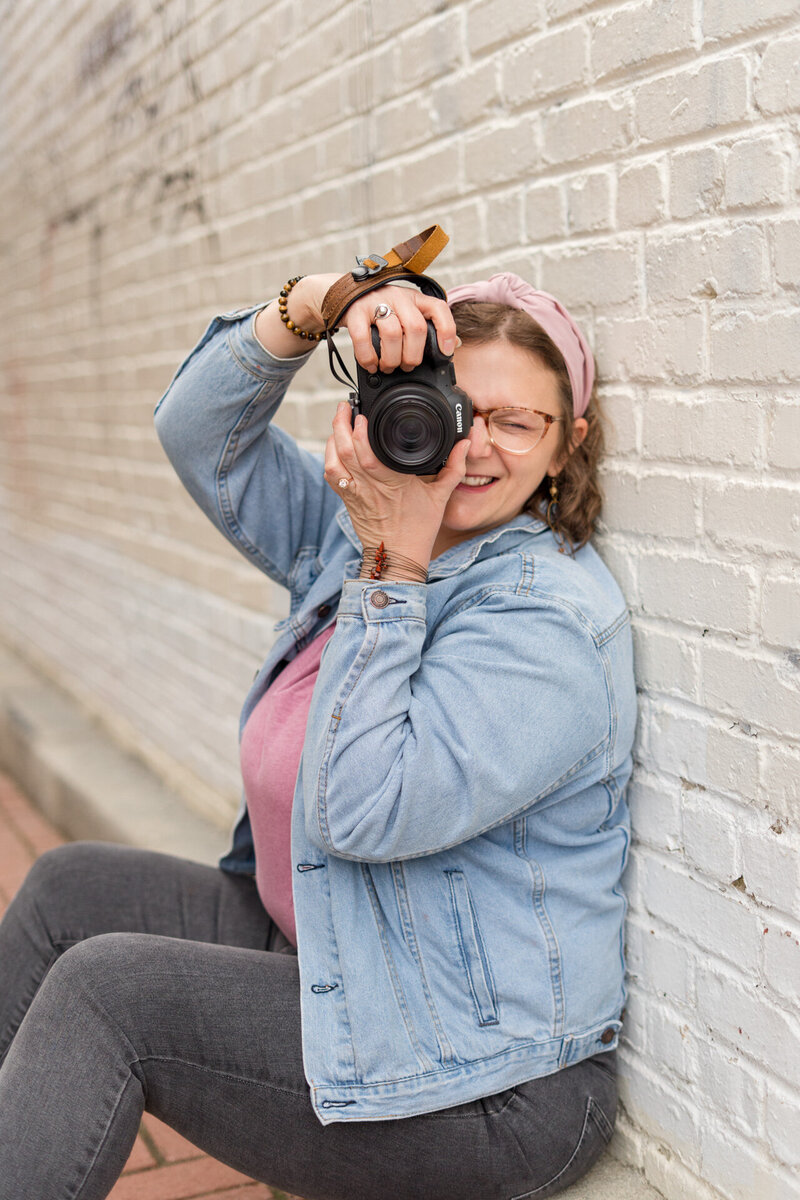 Boone, NC based family, wedding and boudoir photographer Ashley Kubota smiles at the camera.
