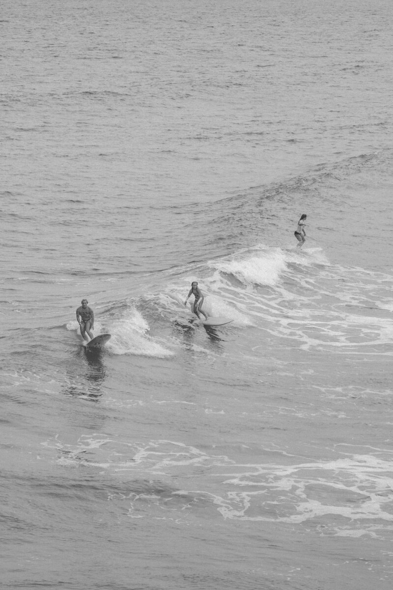 A group of surfers catch a wave together
