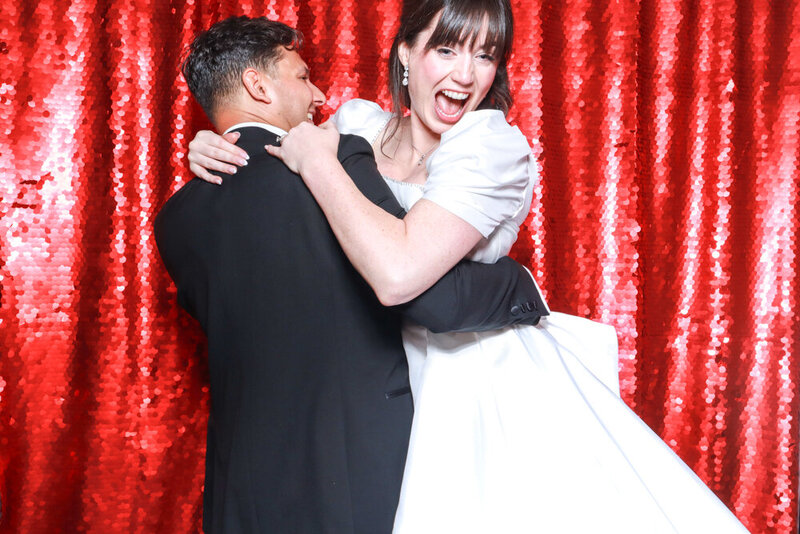 red sequins wedding backdrop photo booth hire with bride and groom having fun