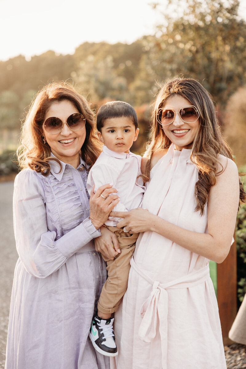 Two women holding a child during a family photoshoot in auckland