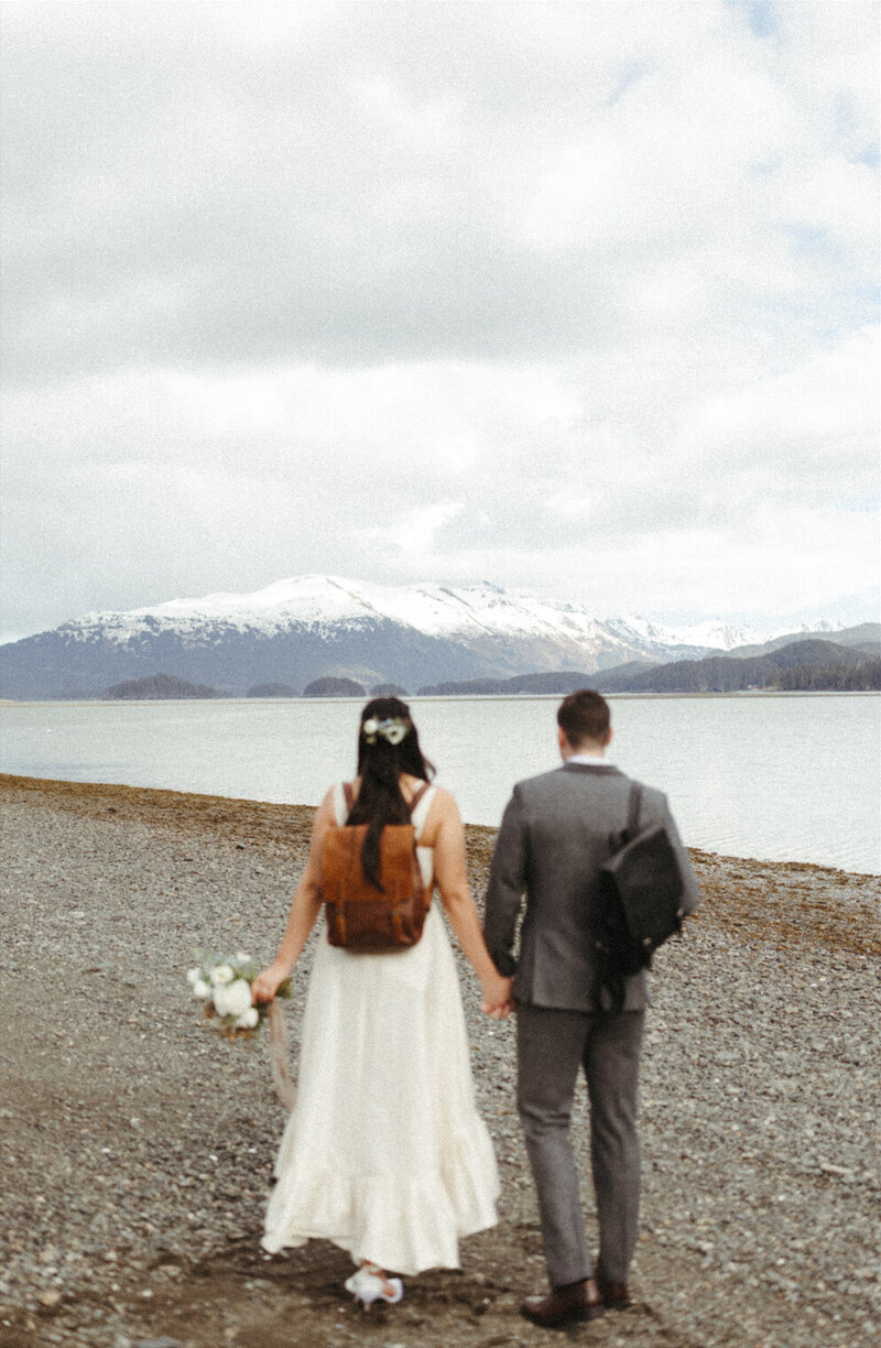 Couple walking along the beach during their Seaside wedding in Homer, Alaska