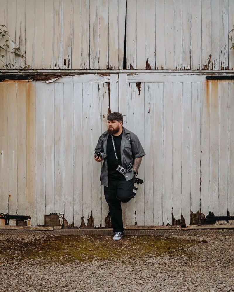 Tom Bowen Photography leans against door