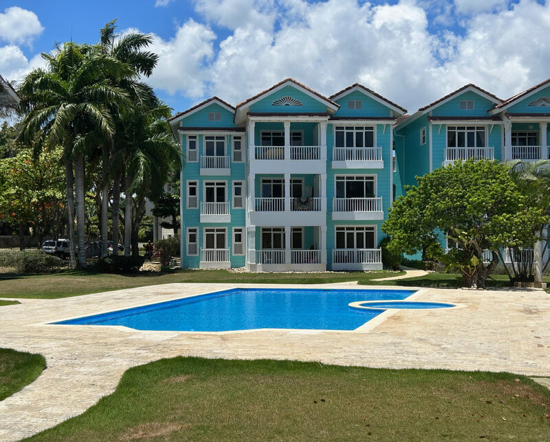 Modern affordable housing development with a central pool in the Dominican Republic, backed by Nova Lux DR’s social responsibility efforts