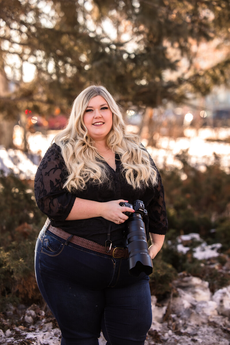Edmonton wedding photographer holds camera and smiles