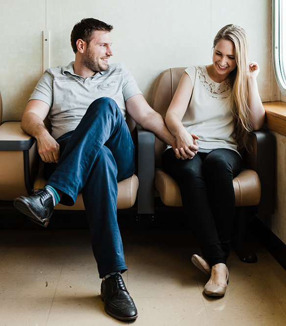 a couple holds hands and laughs together while riding a ferry during their Seattle engagement session with seattle elopement photographer amy galbraith