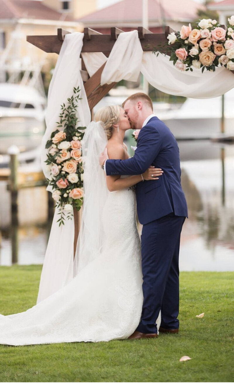 wedding venue pensacola with this bride and groom just married on the waterfront with a beautiful arbor with forals.  Romantic Venue, hostoric architecture venue, venue with a story, unique pensacola venues, dream wedding in pensacola