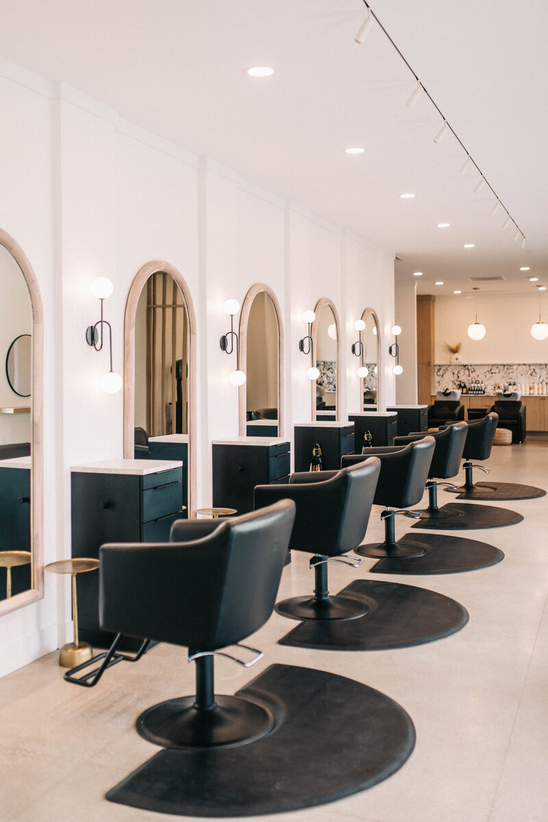 Modern and inviting hair salon interior with styling chairs, mirrors, and shelves featuring Davines hair products in Fort Wayne.