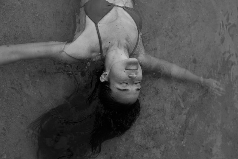 Dreamy photo of Courtney Claire Beglin floating in the ocean, her hair drifting out of frame to indicate creativity and inspiration
