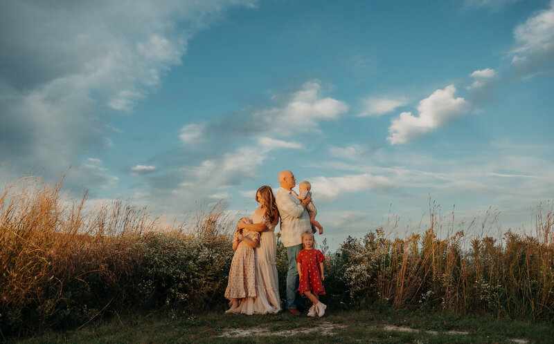 Family of five sitting in a southeastern wisconsin field at sunset.