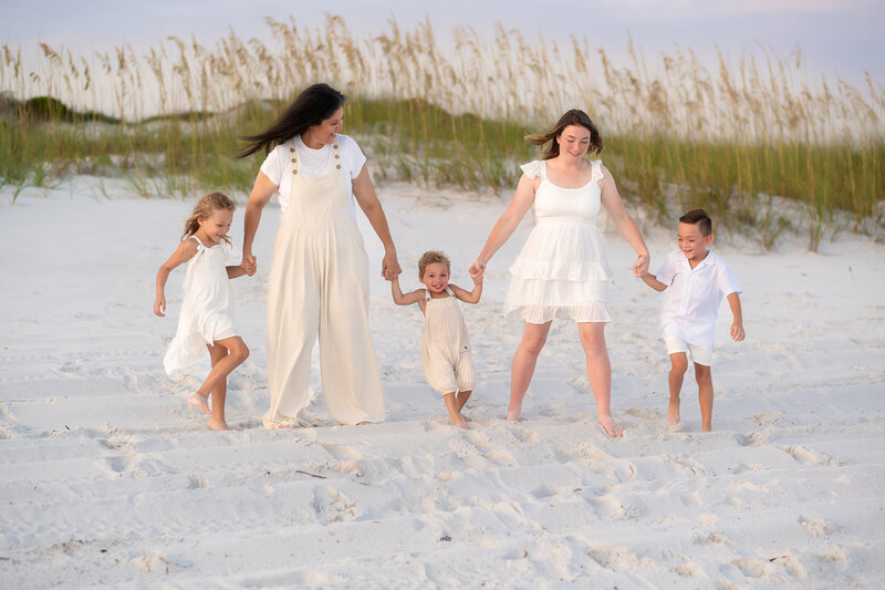 A LQBTQ family plays on the beach of 30A.