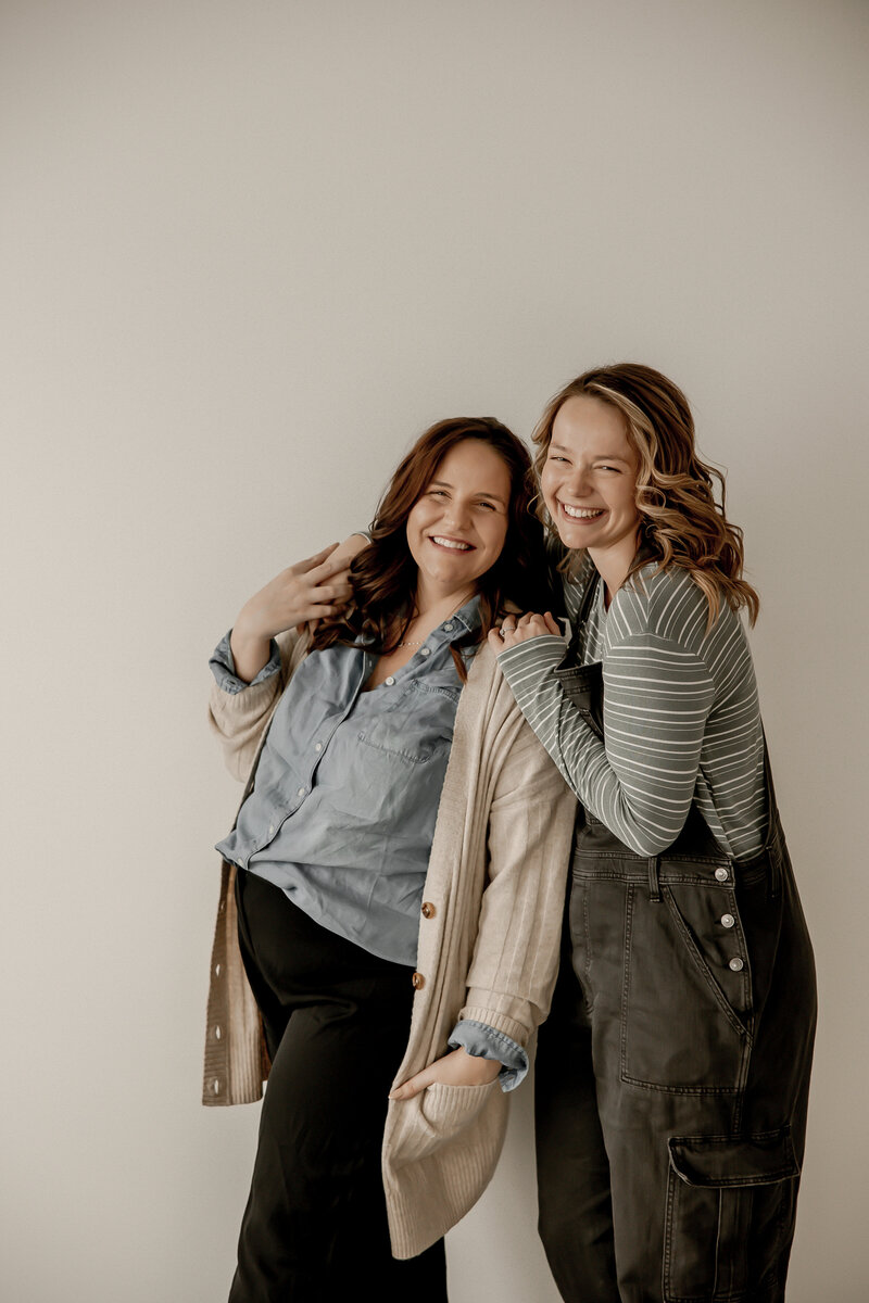 Amber hugging Lacey while smiling at the camera