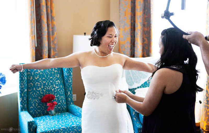 Happy bride in her bright stylish hotel room at the Hotel Monaco in Denver Colorado