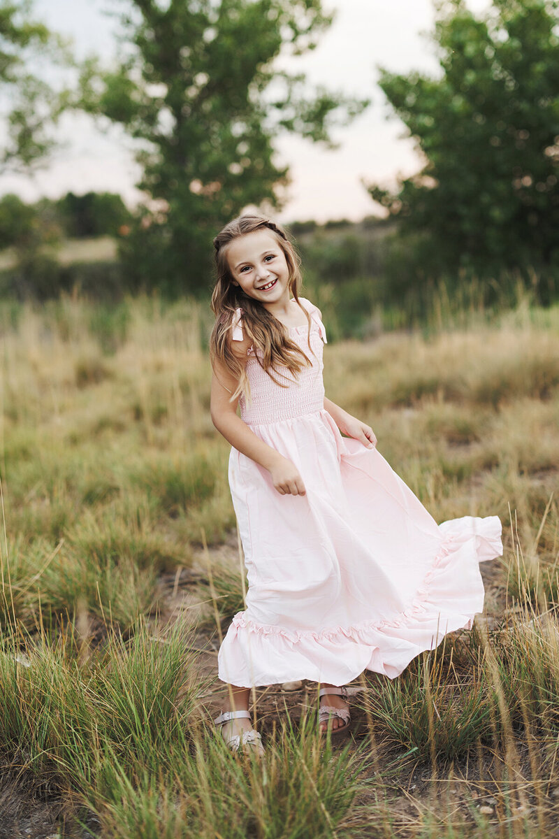 Adorable girl twirling in a field
