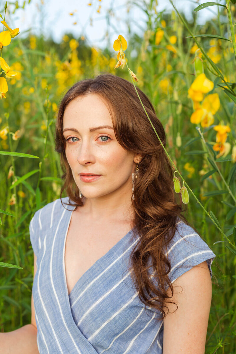 Woman in blue dress in field of yellow flowers