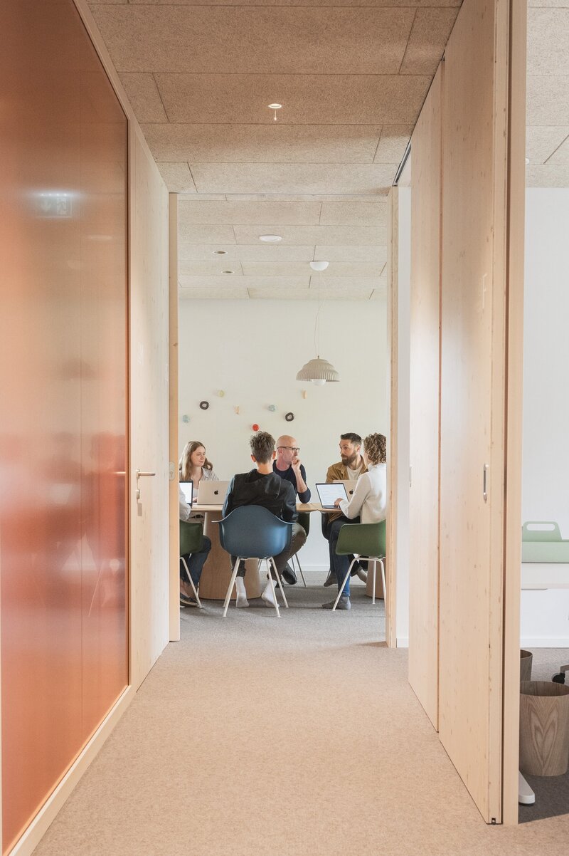 Team having a productive workshop session in one of The Campus Alps Workbase's modern meeting rooms, perfect for company retreats and collaborative work in the heart of the Alps.