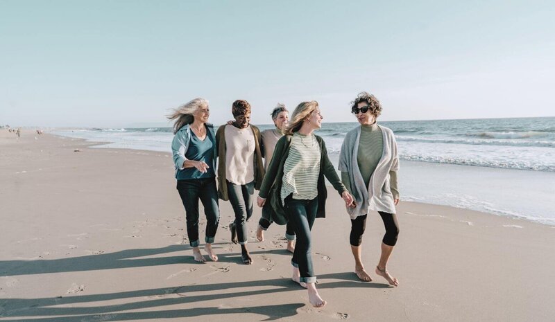 Group of midlife women walking together on the beach