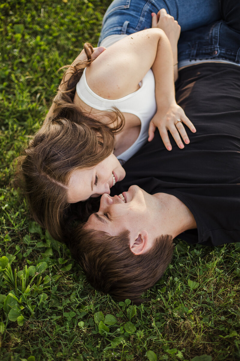 young engaged couple laying in grass during Knoxville engagement session