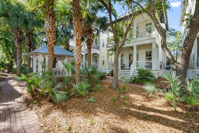 Palm trees and native plants surround the inviting porch of Tangerine Dream vacation rental