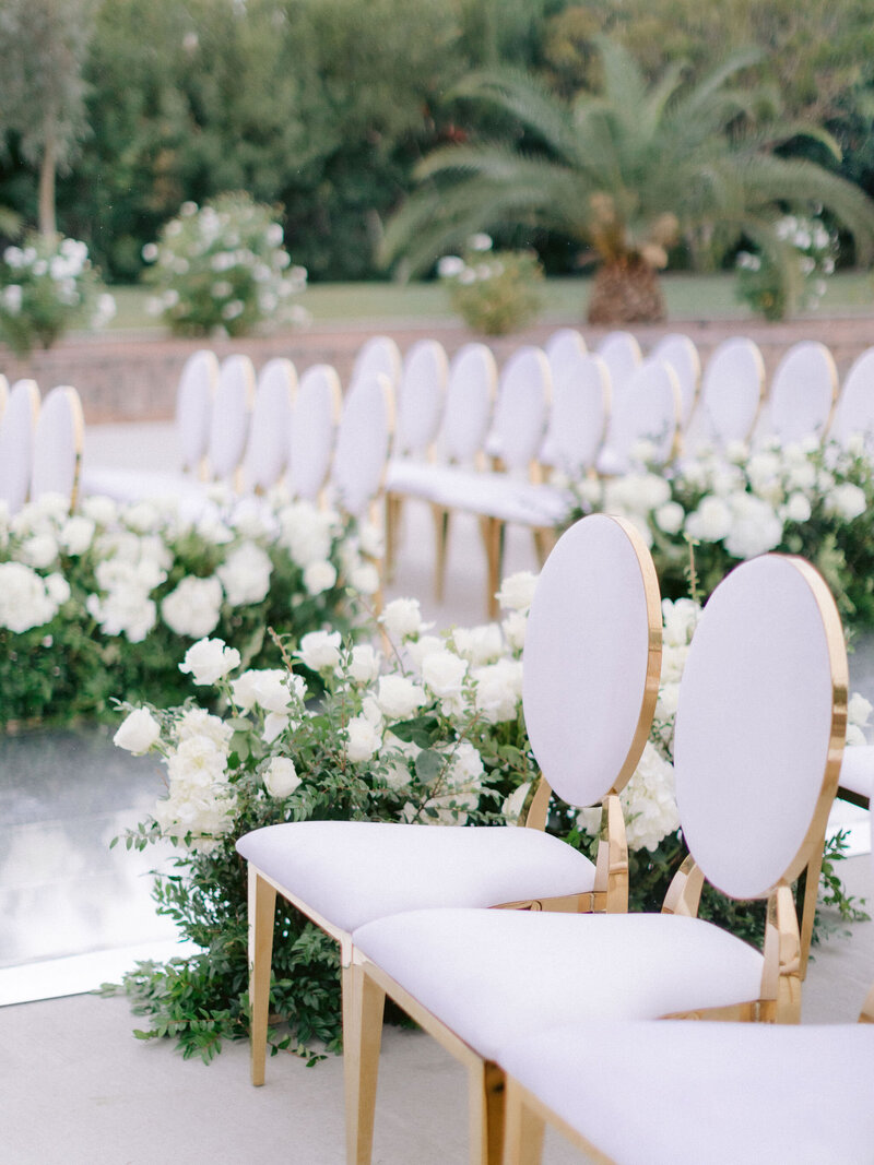 white wedding chairs with white flowers