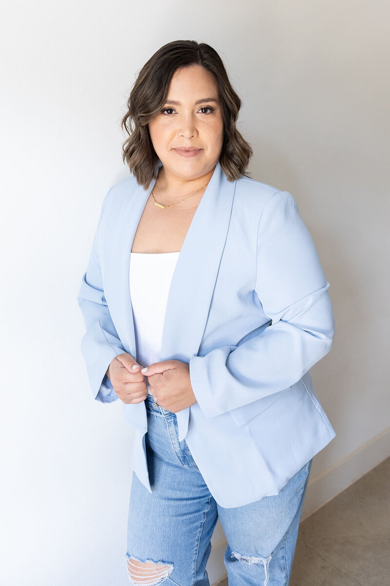 Portrait of Eventive Designs founder wearing a light blue blazer and denim, an Austin-based wedding planner specializing in modern event design.