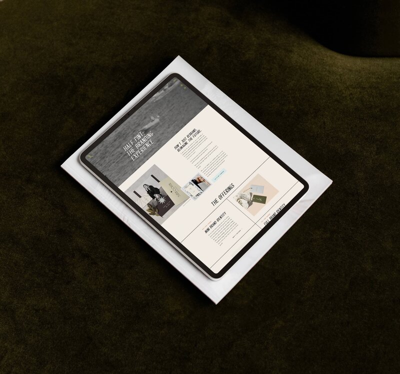 A tablet displaying a website with text and images is placed on top of a closed white laptop, both resting on a dark green surface—perfect for showcasing creative branding and website design.