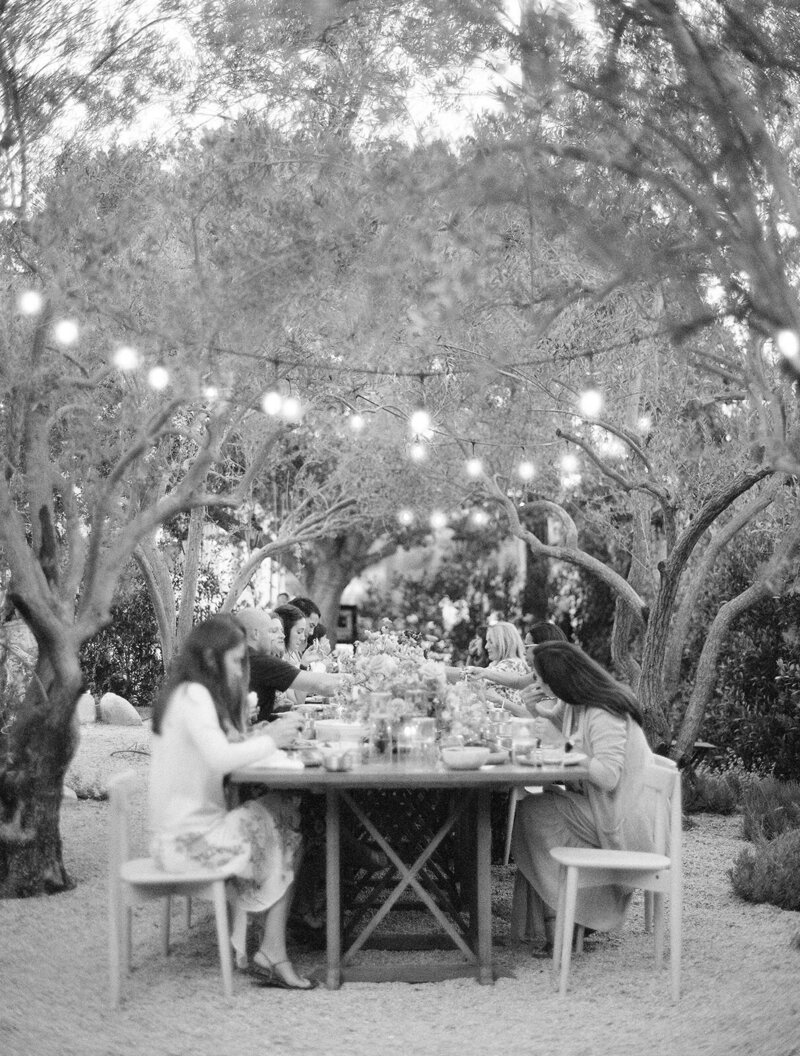 guests enjoying dinner under string lights