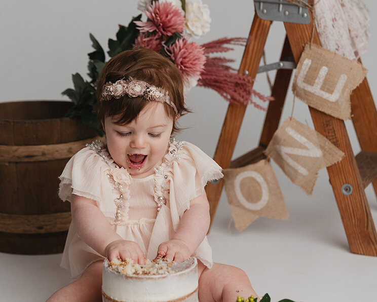 Girl gets excited smiling for her first birthday cake.