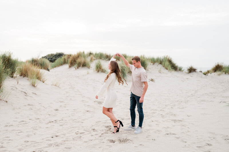 Een stel deelt een vrolijk moment tijdens een loveshoot in de natuur, vastgelegd door Monica Stout Fotografie in een ontspannen setting.