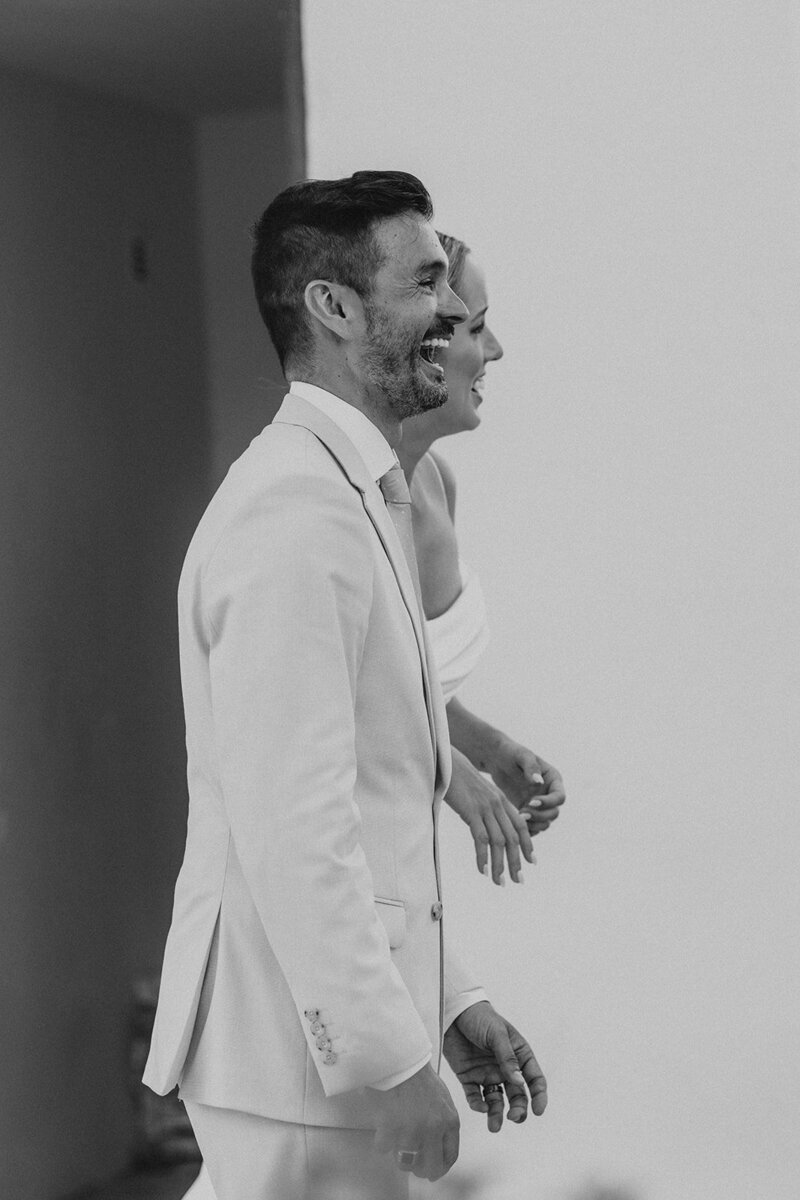 Close-up of couple clinking champagne glasses in black and white — cinematic wedding detail highlighting intimacy and celebration.