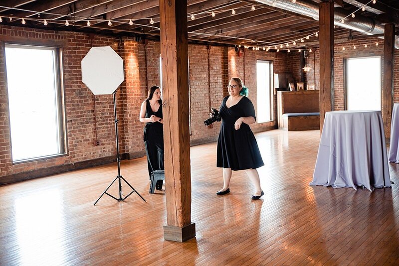 Mahlia and assistant standing inside Cannery wedding venue as she directs the bride