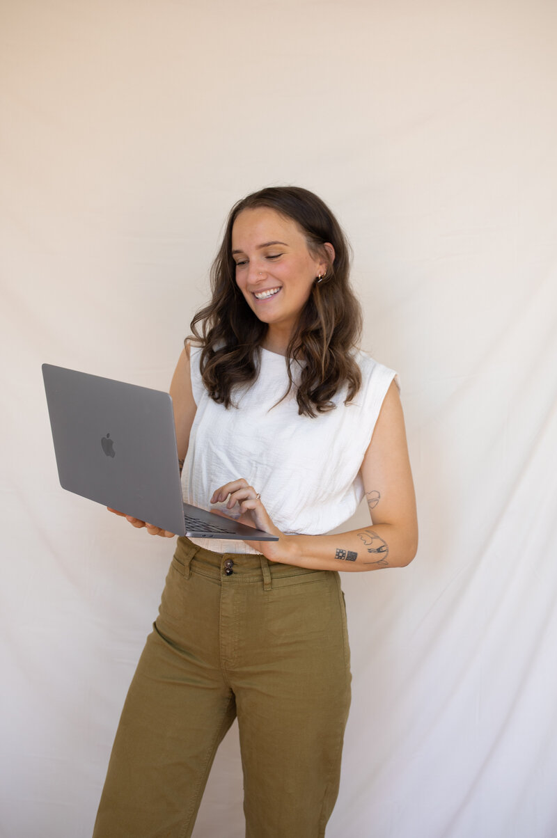 A woman working on freelance website design on her computer.