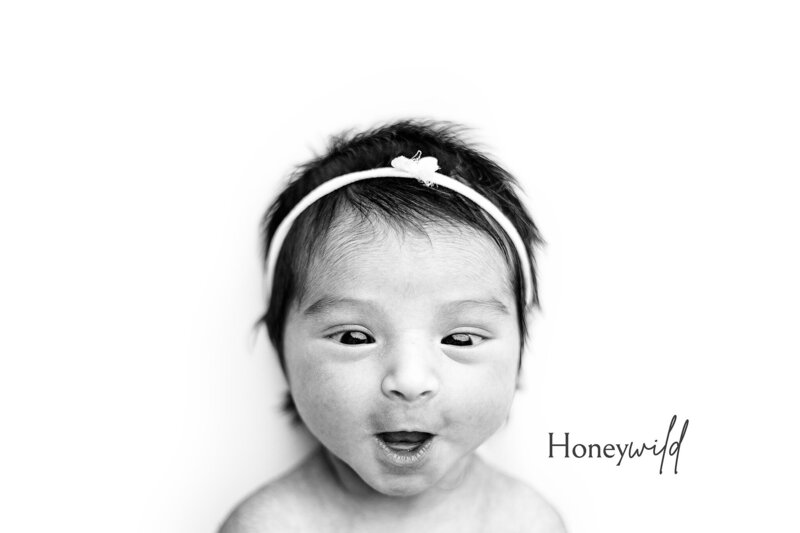 Newborn photographer in Grand Rapids captures swaddled baby smiling with headband