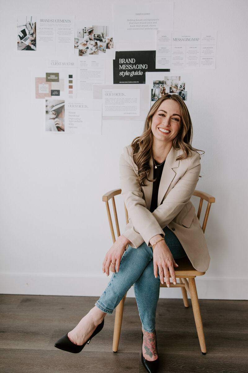 Portrait of website copywriter Erika Fitzgerald sitting in front of a website strategy whiteboard 