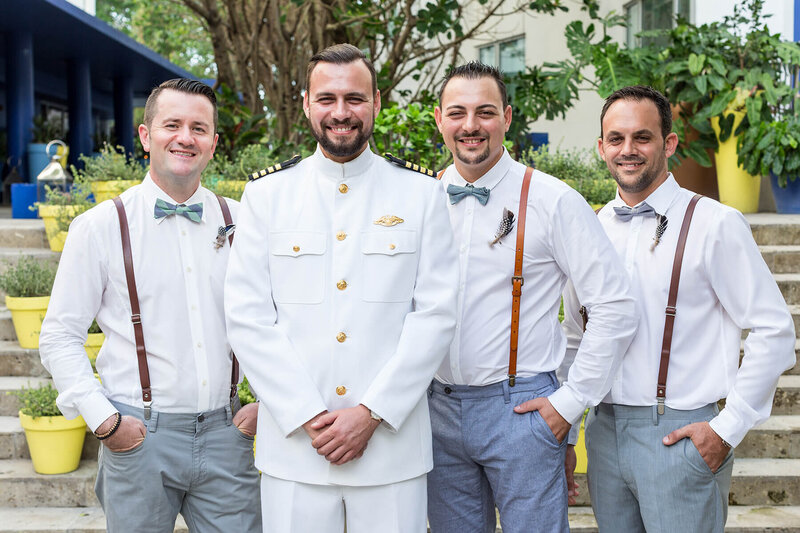 Groom and his groomsmen pose for a formal portrait before the wedding ceremony outdoors.