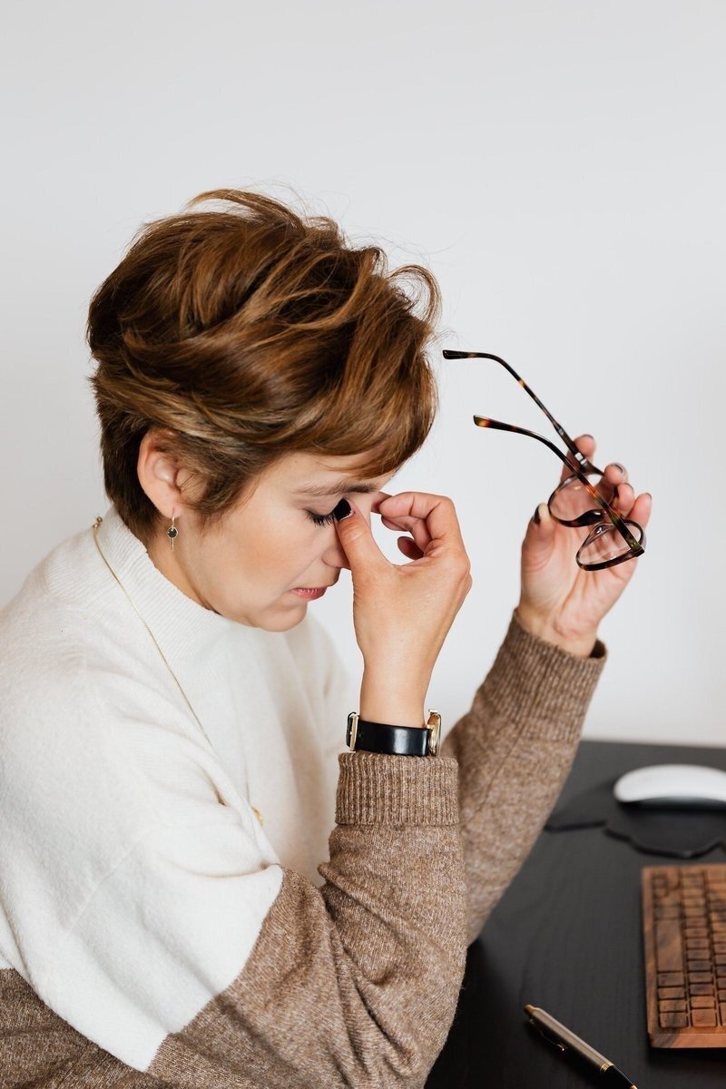 A person browsing 'Ways to Work Together' on a mobile phone with a vase of white flowers in the background