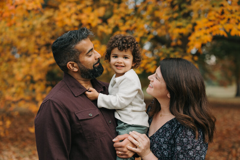 Brunette mom and Indian father looking at son at Francis Park