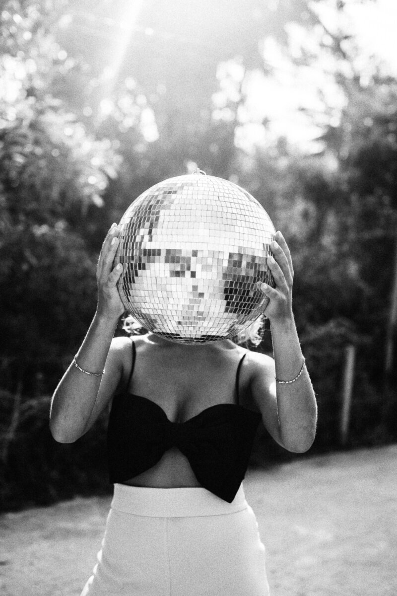 Woman covering her face with a disco ball
