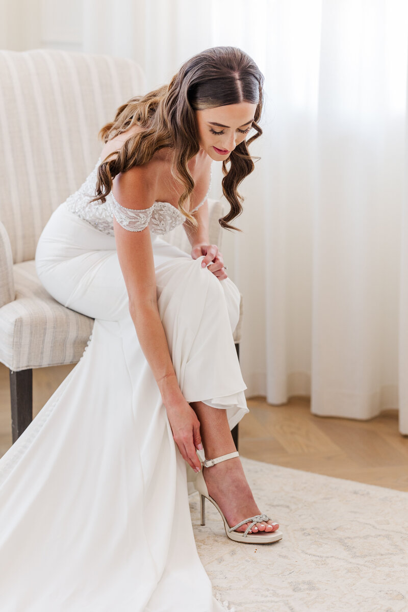 bride-buckling-her-shoe-before-in-the-bridal-suite-before-the-ceremony