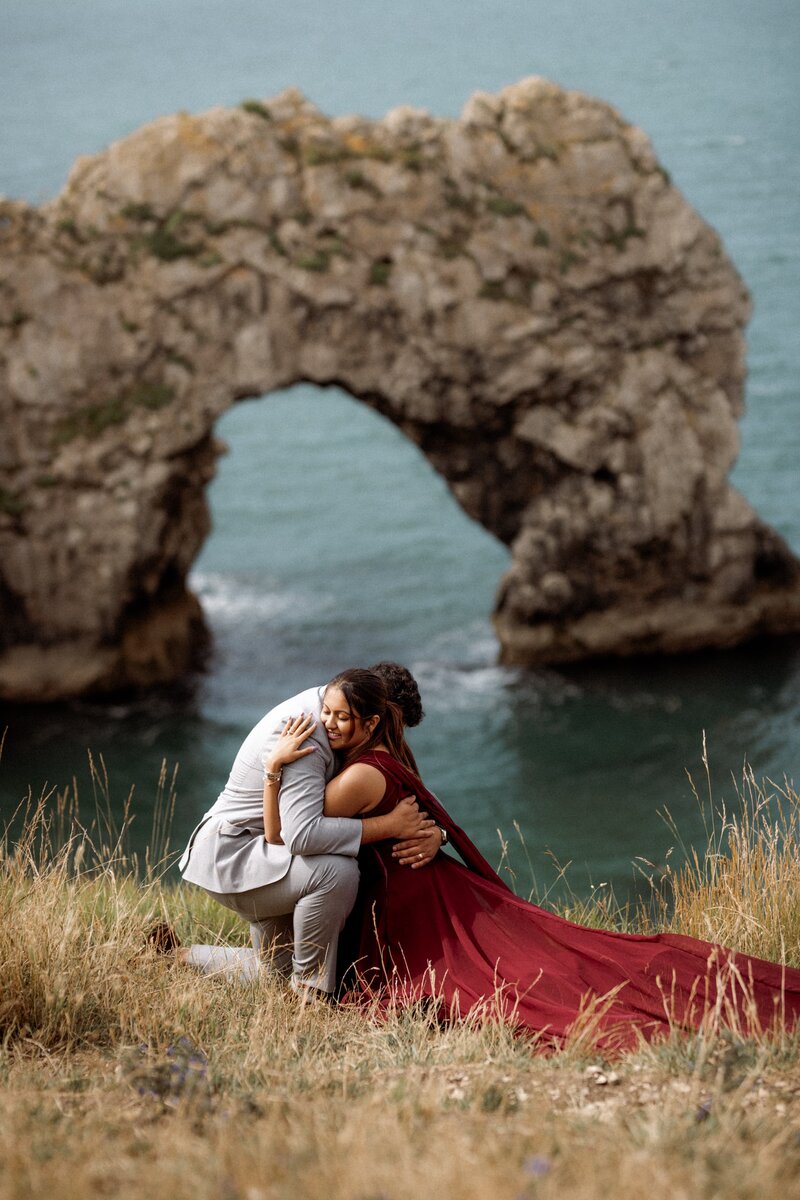 Beach elopement photography couple having intimate moment hugging eachother posing for UK elopement photographer at Durdle Door in dorset