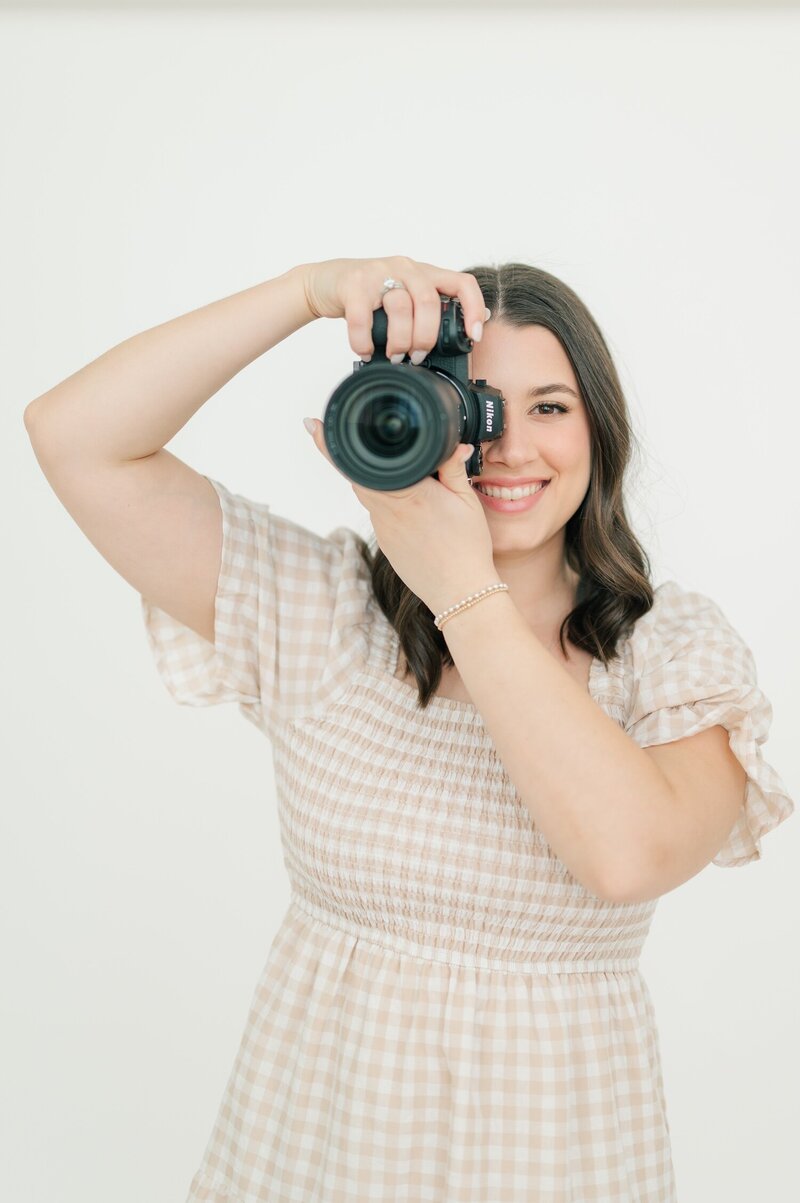 Ephe holding her Nikon camera at Nikki Estephan Studio. 