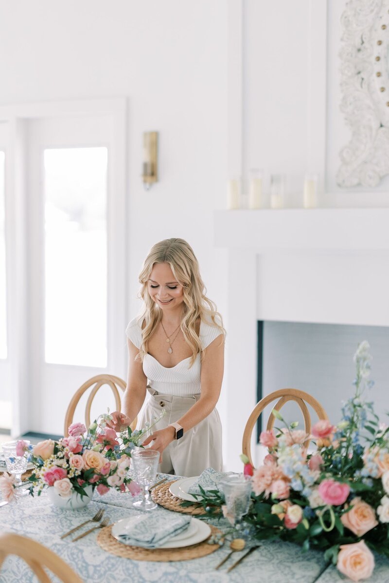Helena Elizabeth, wedding planner tampa fl, adjusting florals on a wedding table