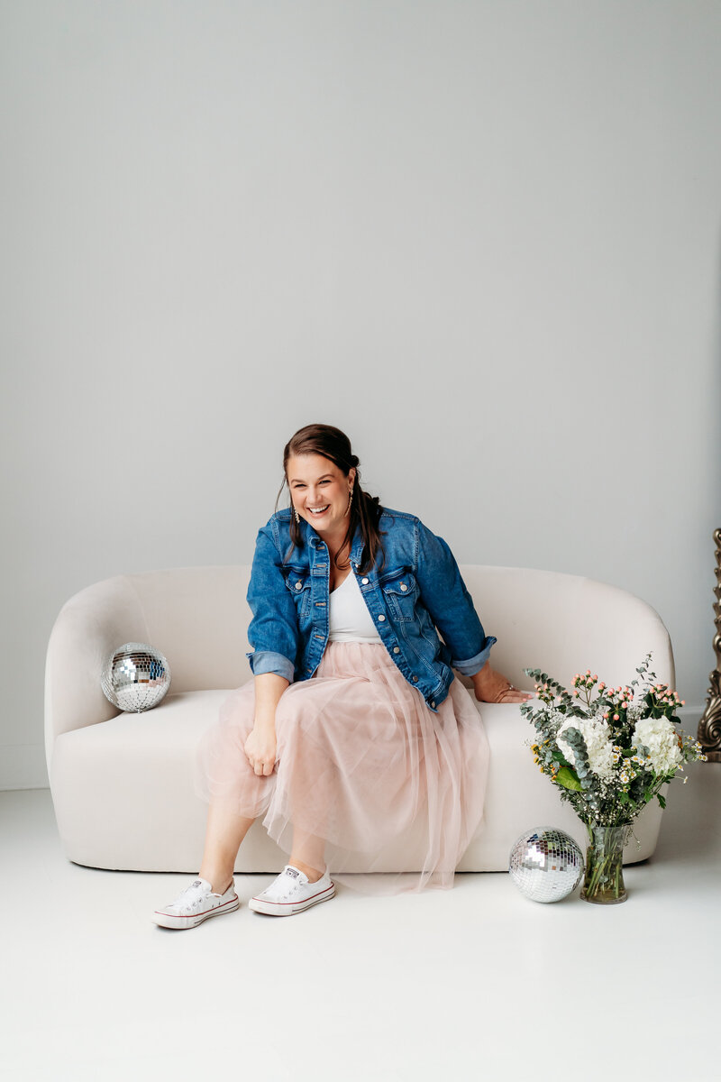 Woman on couch smiling.