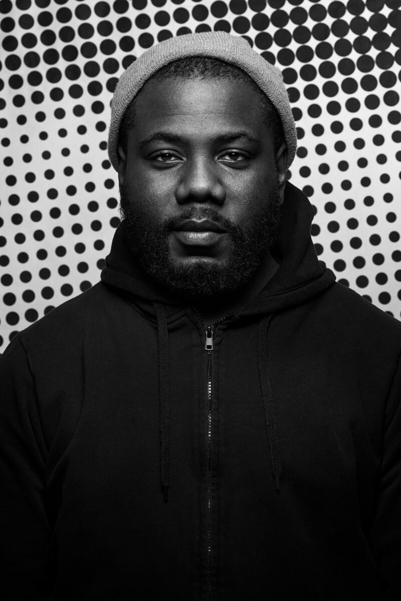 Powerful black-and-white portrait of Kweku Mandela with a serious expression, captured by Ylva Erevall.