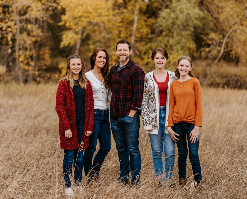 Family of five stands together in the fall during their family photo session with Fort Collins, Colorado family photographer Avenir Photo Co.
