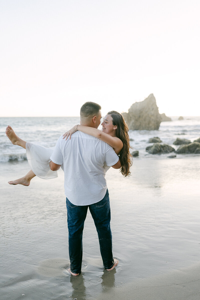 man carrying a woman on the beach