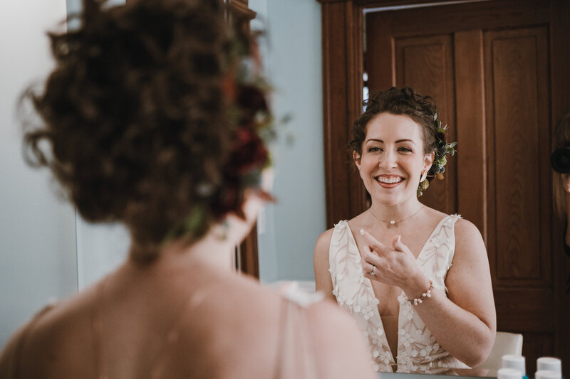 bride smiling at herself in a mirror