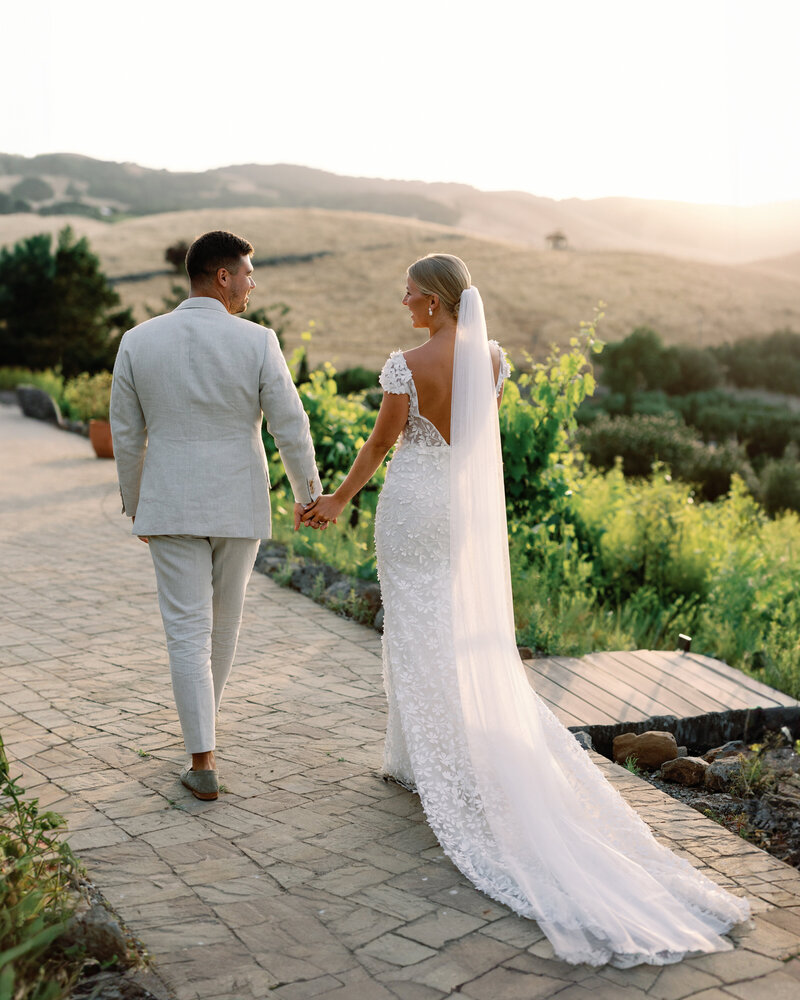 Bride and groom walking through the vineyards at Viansa Winery in Sonoma, California. Golden hour wedding portraits.